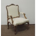 A large carved French Fauteuil, covered in cream coloured damask, on cabriole legs.