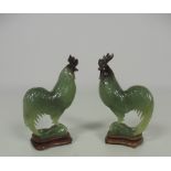 A pair of well modelled carved jadeite figures of Cockerels, on carved hardwood stands,