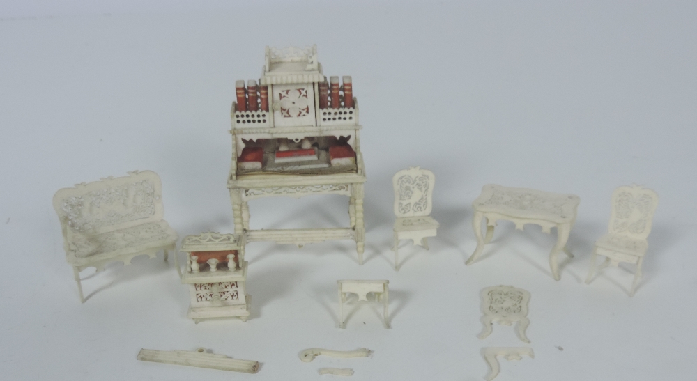 A very finely carved and pierced late 19th Century ivory Dolls House Set of Furniture,