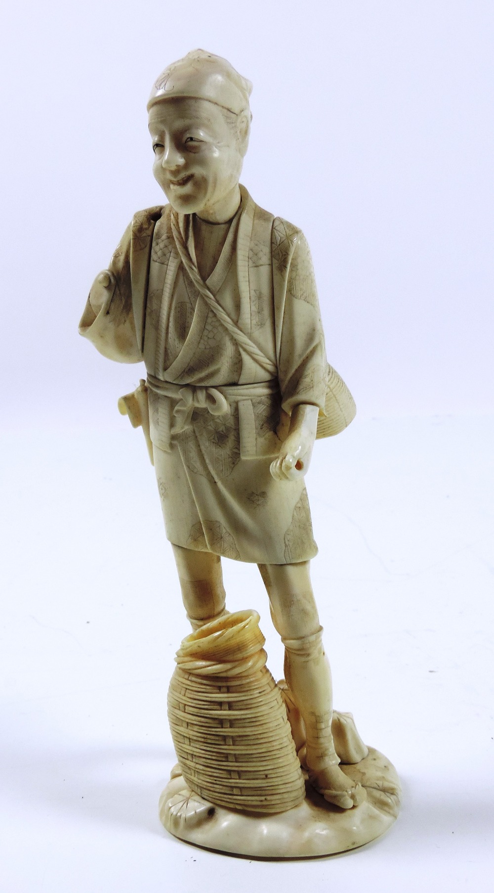 A tall 19th Century carved and engraved Japanese ivory Okimono, of a man with baskets etc, - Image 2 of 2