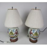 A pair of painted porcelain Table Lamps, of bulbous shape, with shades.