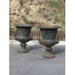 A pair of heavy antique metal Garden Urns, each with two mask handles, 24" high approx.