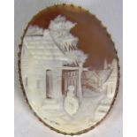 A very fine gold carved Cameo Brooch, of a woman standing outside a house, with safety chain.