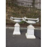 A pair of Victorian cast iron two handled Garden Urns, on decorated bases, each approx.