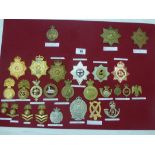 BOARD OF ASSORTED CAP BADGES INCLUDING ROYAL MARINES