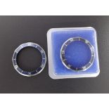 Two Omega Seamaster blue bezels, ref. 082SU1361, one within Omega sealed packaging, one used (2)