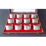 Good cased set of twelve silver oval napkin rings with gadrooned borders, maker A Haviland-Nye,