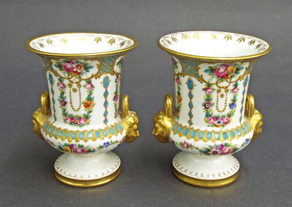 Pair of French porcelain twin-handled vase urns in the manner of Sevres, decorated with various