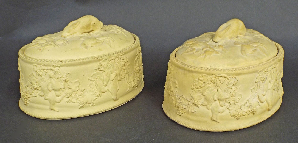 Pair of Wedgwood buff earthenware tureens, decorated in relief with various game and mounted by a