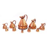 Graduated set of ten copper jugs, ranging from two gallons to 1/8th gill, the largest 16" high,