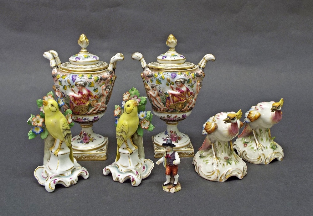 Pair of Capo di Monte twin-handled porcelain urns decorated in relief with a chariot scene with