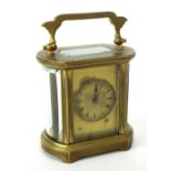 French carriage clock timepiece, the gilt mask dial within an oval sided brass case, 4.5" high