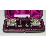 Victorian Pair of Silver Salts Complete with Spoon. Embossed Decoration to Bodies.