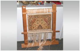 Small Persian Carpet, fixed to a wooden loom frame. Showing the technique of carpet making.