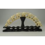 Japanese Late 19th Century Ivory Tusk Carving of a Group of Elephants Raised on a Black Ground,