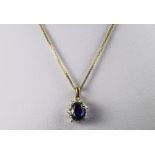 9ct Fine Link Chain Suspending A Yellow Metal Blue Stone Pendant.