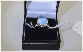 Larimar Solitaire Ring, a 7ct trillion cut cabochon of larimar, a rare, mottled baby blue stone,