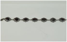 Edwardian Silver and Marcasite Set Bracelet with Seven Faceted Garnet Coloured Stones. Marked 925.