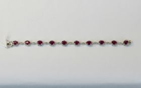 Ruby and White Topaz Bracelet, ten oval cut rubies in milgrain frames of rhodium vermeil and silver,