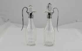 Two Glass Condiments, Oil and Vinegar, silver handles and spouts. Hallmark for London 1900.