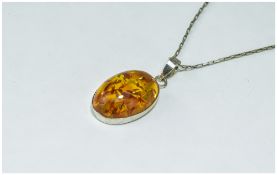 Silver Mounted Amber Pendant suspended on a silver chain.