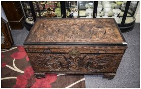 Early 20thC Chinese Camphor Chest profusely carved to hinged top, front and sides depicting home