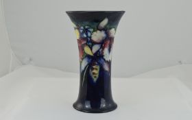 Moorcroft Trumpet Vase, orchid design on blue ground. 8 inches in height.