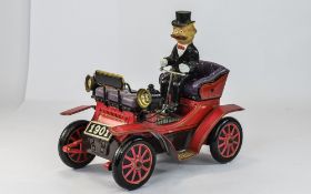 A Vintage Battery Driven Hand Painted Tin Car and Driver In The Style of an Early 20th Century