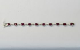 Ruby and White Topaz Bracelet, ten oval cut rubies in milgrain frames of rhodium vermeil and silver,