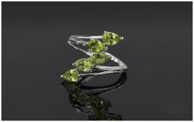Peridot Five Stone Crossover Ring, five pear cut peridots in a scattered line formed by the