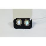 Natural Opal and White Topaz Stud Earrings, each earring comprising an oval cut Ethiopian opal