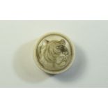 A Small Early 20th Century Ivory Circular Lidded Pill Box with Image of a Tigers Head to top of Lid.