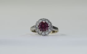 9 Carat Gold Dress Ring central ruby red coloured stone surrounded by clear faceted. Stamped 9ct.