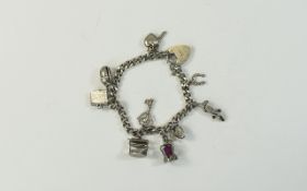 A Vintage Silver Charm Bracelet Loaded with 11 Silver Charms. All Fully Marked for Silver.