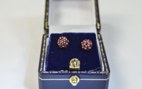 Set of Ladies 9ct Gold Ruby stud earrings. Each set with 7 round cut rubies in a flowerhead setting.