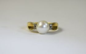 18 Carat Gold Diamond And Pearl Set Ring central pearl set between four round cut spacers.