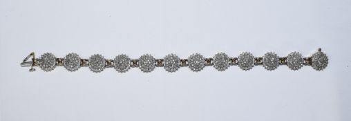 A 9ct Gold and Diamond Bracelet - Set with 12 Circular Flower Head Shaped Diamond Clusters.