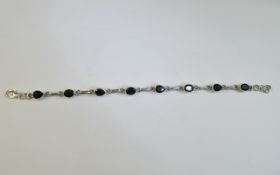 Silver Gem Set Bracelet set with dark oval and pear shaped sapphires.