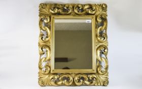 Contemporary Gold Rococo Framed Mirror, mirror measures approx 33 by 42 inches.