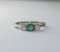 White Gold Diamond/Emerald Ring Plain White Gold band with three small central stones,