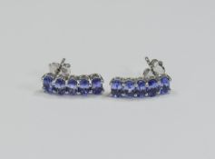 Tanzanite Curved Drop Earrings, each earring comprising five oval cut tanzanites,