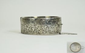 A 1950's - Nice Quality Silver Wide Banded and Floral Engraved Hinged Bangle with Safety Chain.