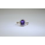 9ct Gold Amythist and Diamond Cluster Ring central oval amethyst surround by round cut diamonds.