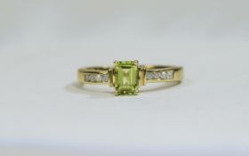 9ct Gold Diamond and Peridot Ring central emerald cut peridot between channel set diamond shoulders.