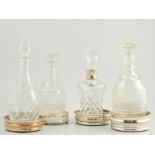 Four various cut glass decanters, one with silver collar,