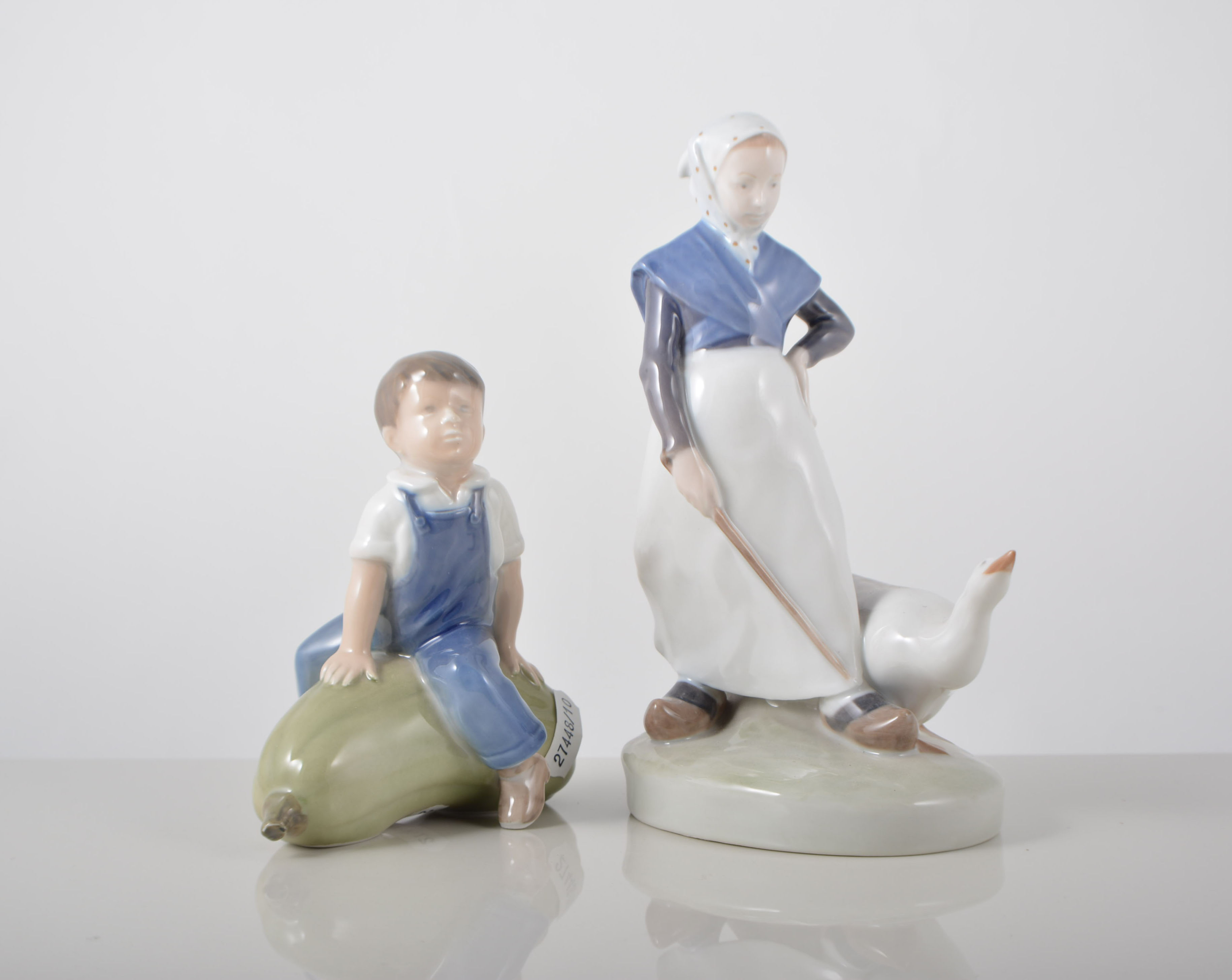 Two Royal Copenhagen figures, a boy seated on a marrow 4539, and a girl with goose 528,