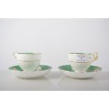 Pair of Victorian cups and saucers, green and gilt borders, painted with floral sprays,