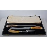 Horn handled and silver mounted carving set, in an oak case, 46cm and another cased carving set,