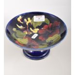 Moorcroft pottery pedestal bowl, flora pattern on a blue ground, diameter 19cm.