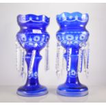 Pair of blue tinted glass lustres, cut decoration with prismatic droplets, with some damage,